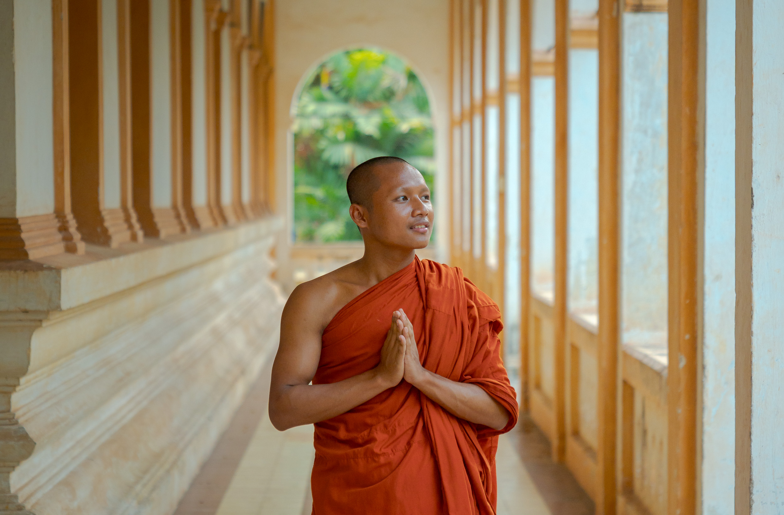 buddhist monk standing inside a temple pavilion in Siem Reap, Cambodia
