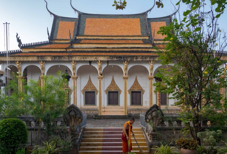 buddhist monk standing inside a temple pavilion in Siem Reap, Cambodia