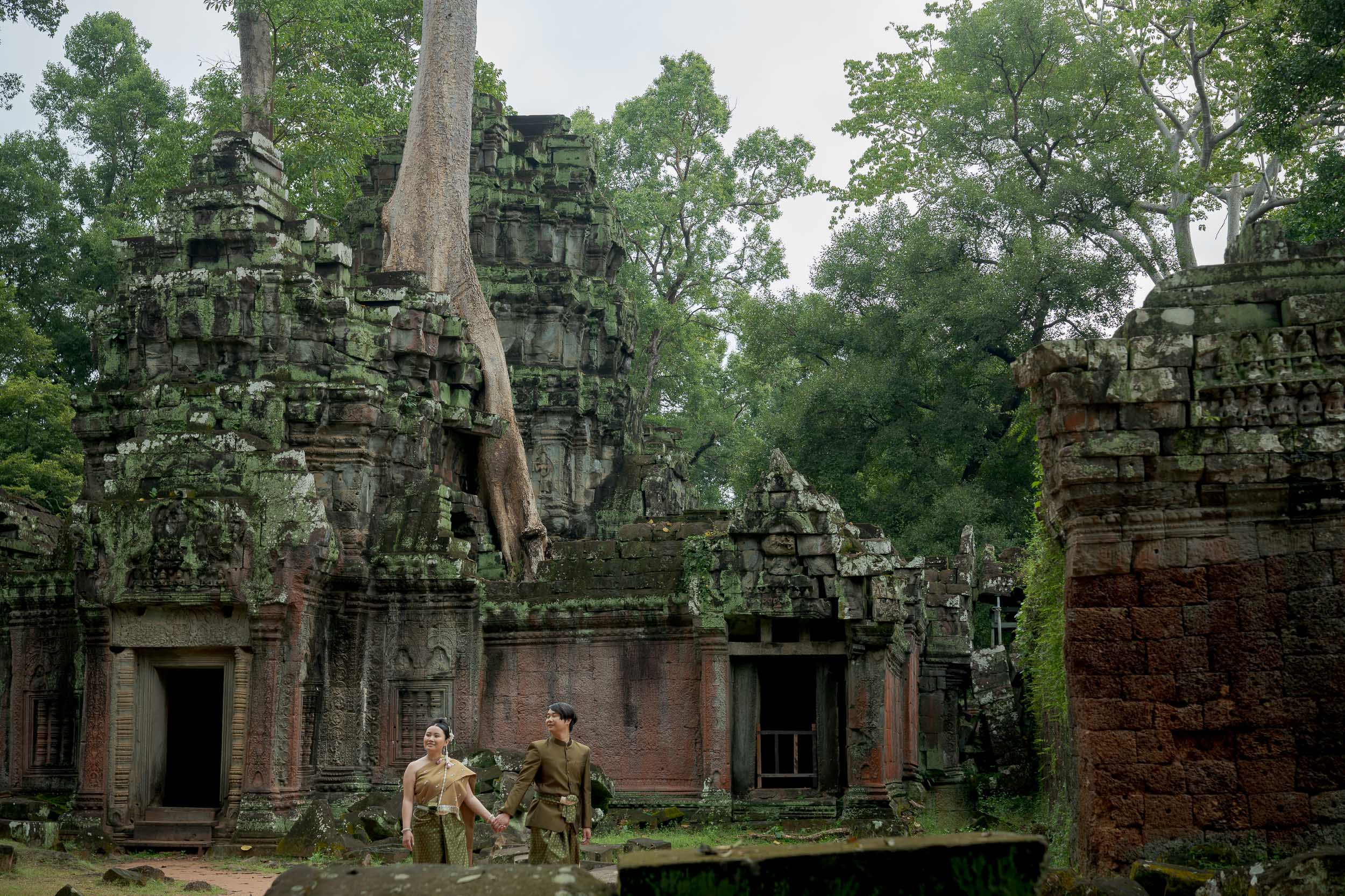 Couple at Ta Prohm Temple in Angkor on a traditional clothes photoshoot captured by Siem Reap Photographer