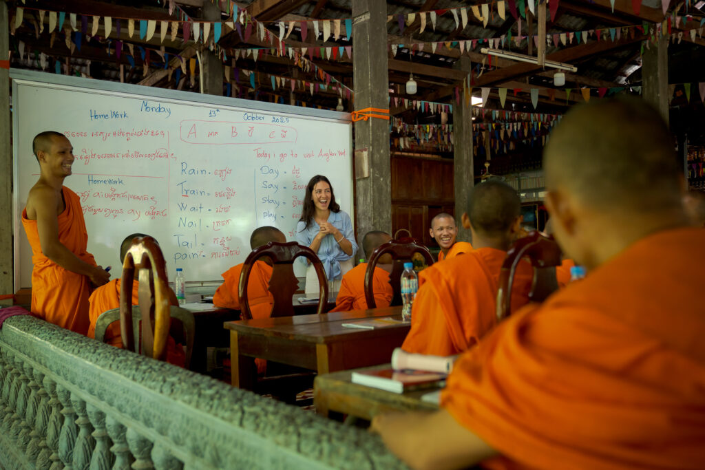 Solo traveller sharing a spontaneous moment with young monks after a traditional monk blessing in Siem Reap