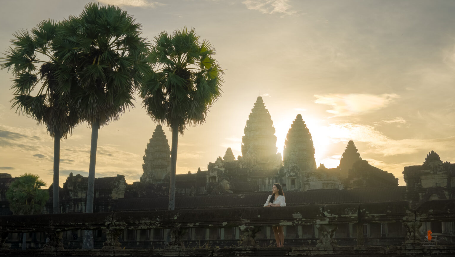 Solo traveller at angkor wat with sunrise appearing from behind angkor wat