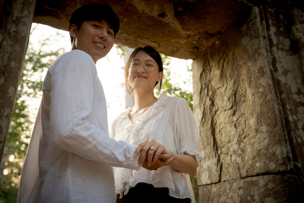 Newly engaged couple beneath a stone doorway at Ta Nei Temple