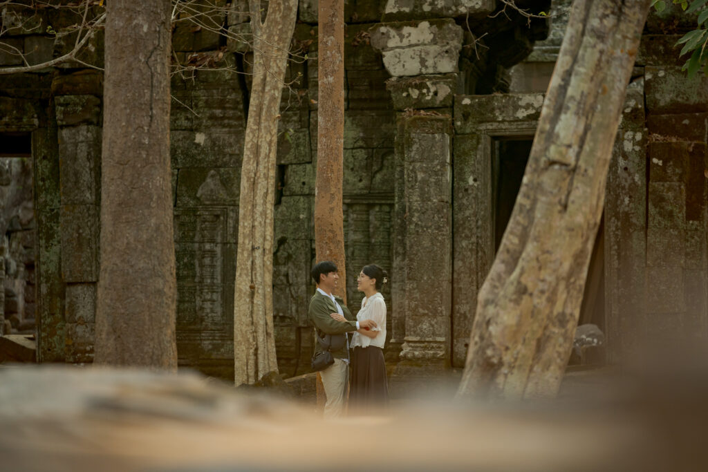Couple walking through the ancient ruins of Ta Nei Temple
